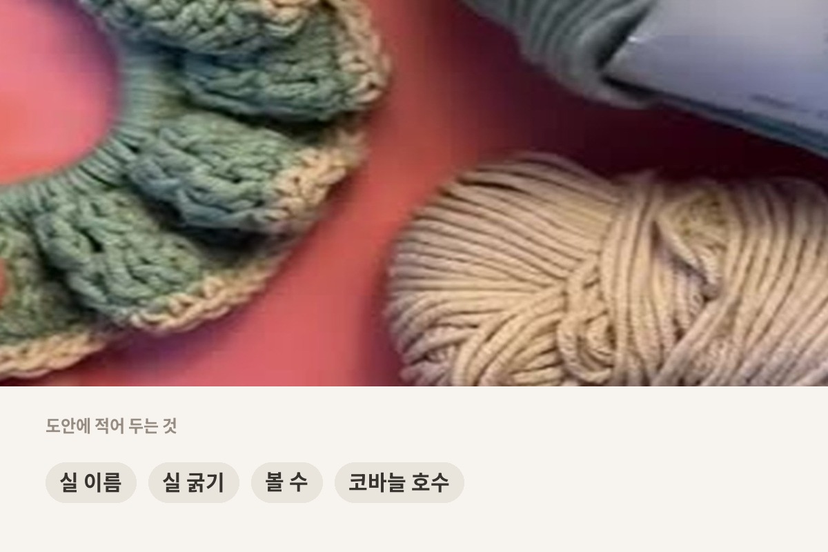 민트색과 베이지색 실 볼이 놓인 작업대